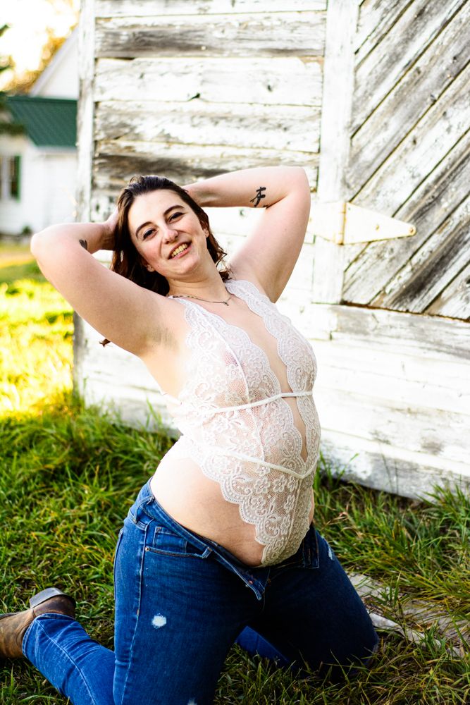 Casual outdoor portrait in white lace and denim against rustic barn setting.