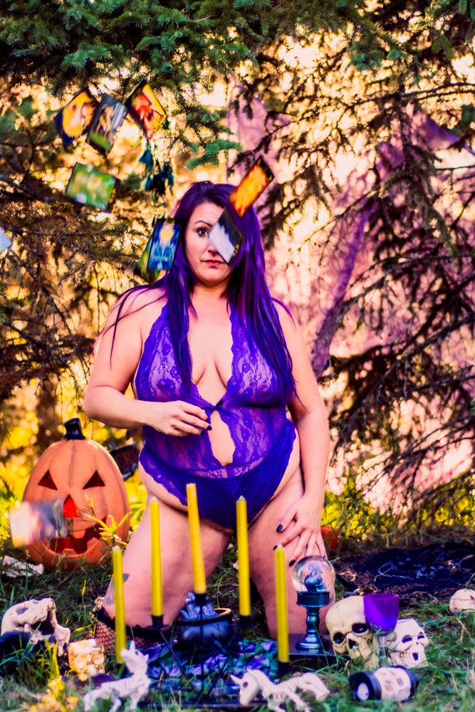 Halloween themed outdoor photoshoot with candles, skulls, and jack-o'-lantern decorations.