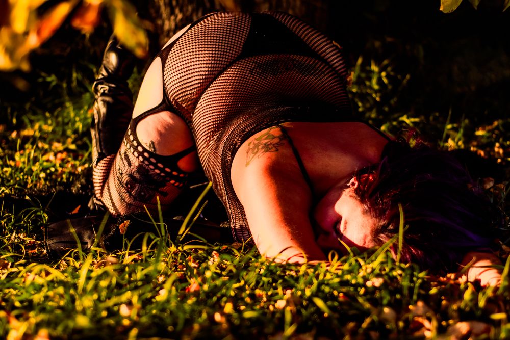 Intimate photo session in dappled sunlight with fallen autumn leaves.