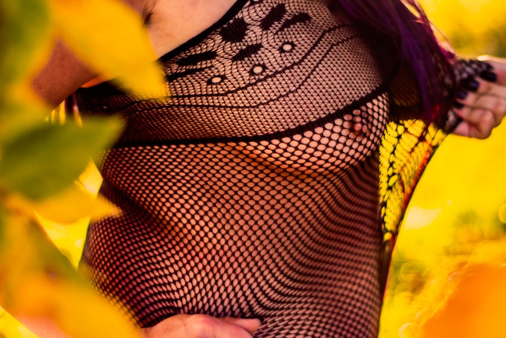 Close-up detail of black lace and fishnet pattern against yellow leaves.