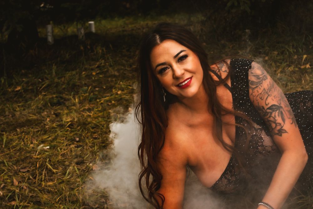 Artistic portrait with smoke effects against a natural forest background.