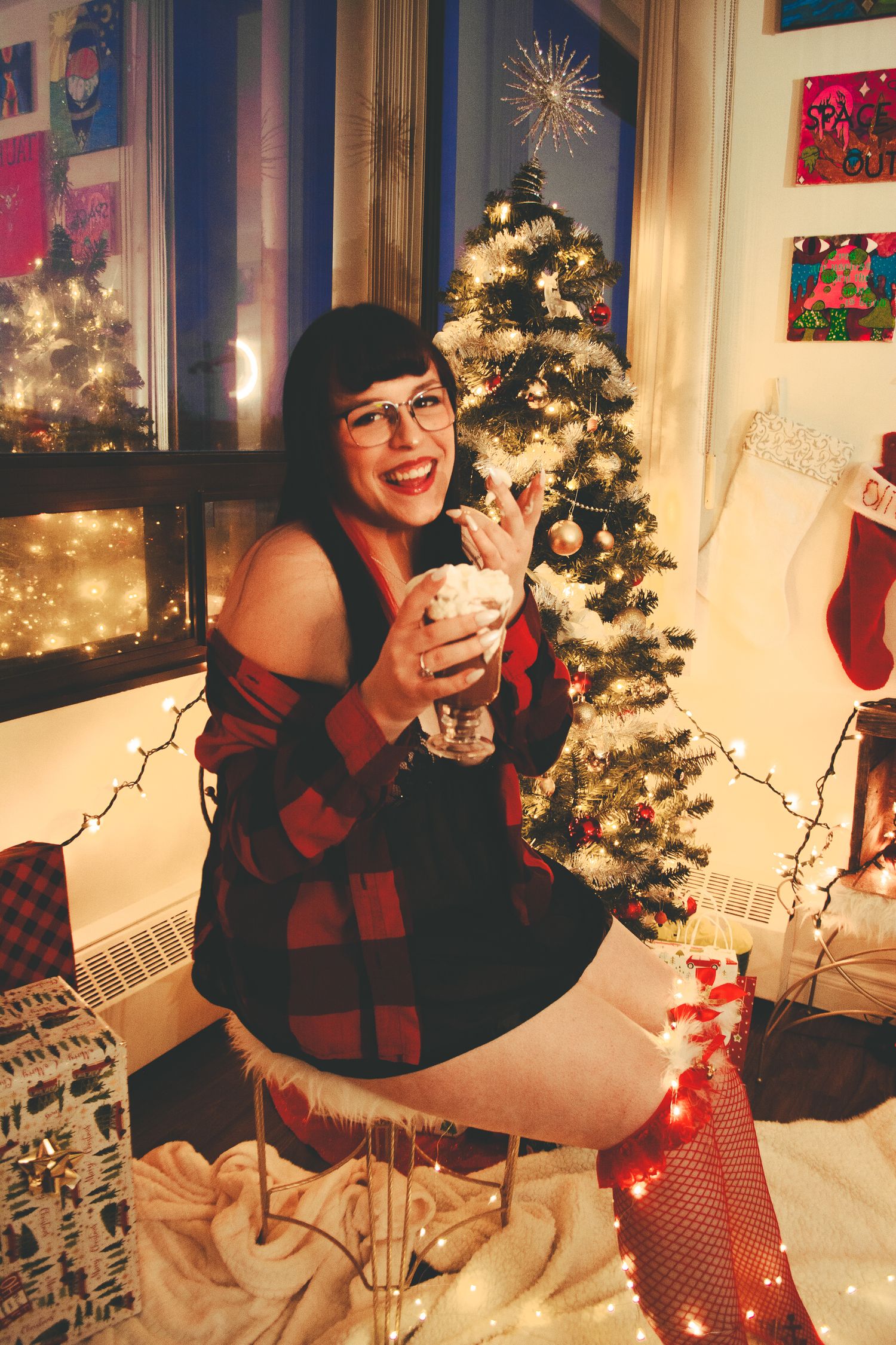 Festive holiday setup with stockings, string lights, and a decorated Christmas tree.