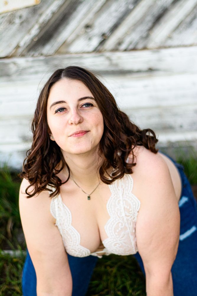 Intimate portrait in white lace against weathered wood backdrop.