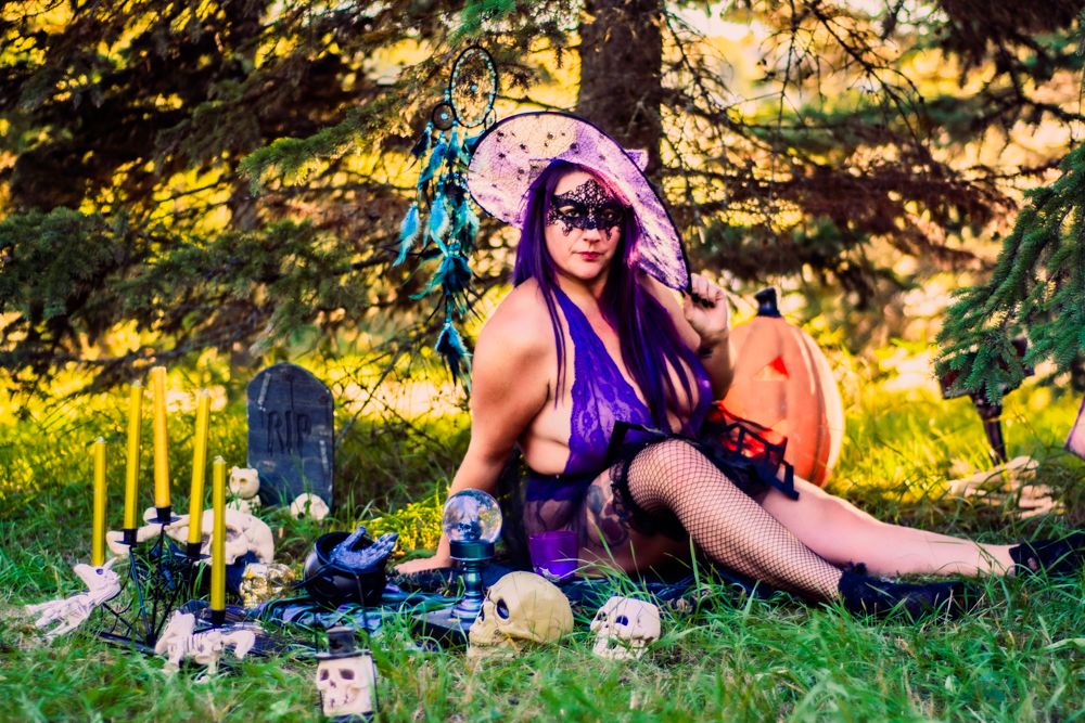 Halloween themed outdoor scene with witchy decorations, pumpkins and purple attire.