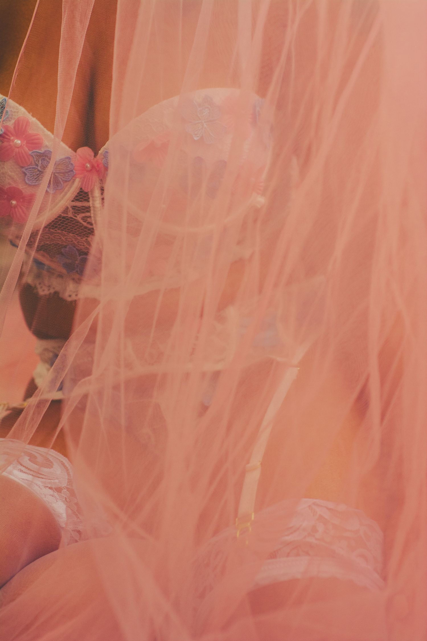 Abstract view through pink tulle fabric creating dreamy feminine texture.