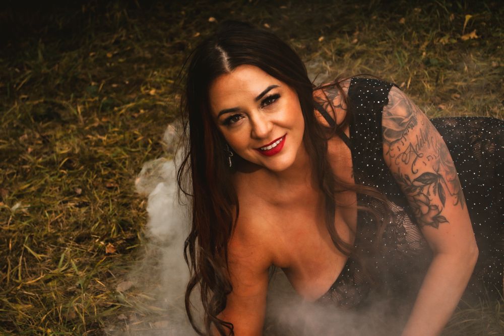 Glamour portrait with dramatic lighting and smoke effects outdoors.
