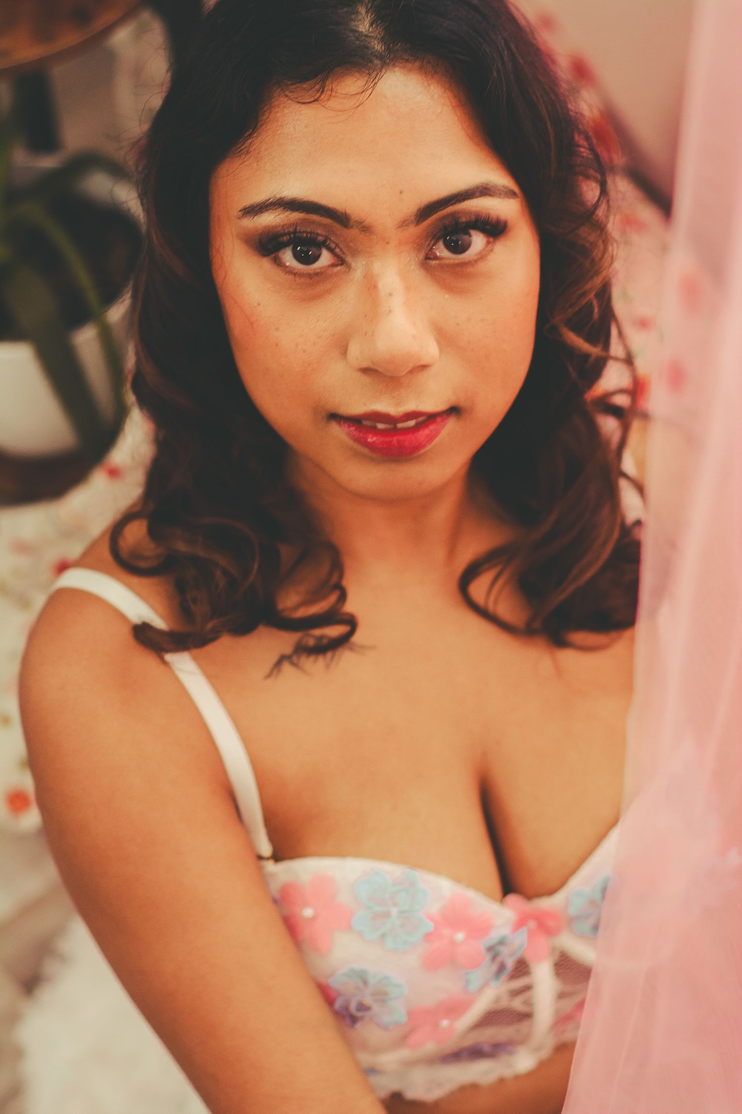 Glamour portrait with floral lingerie against pink tulle background.