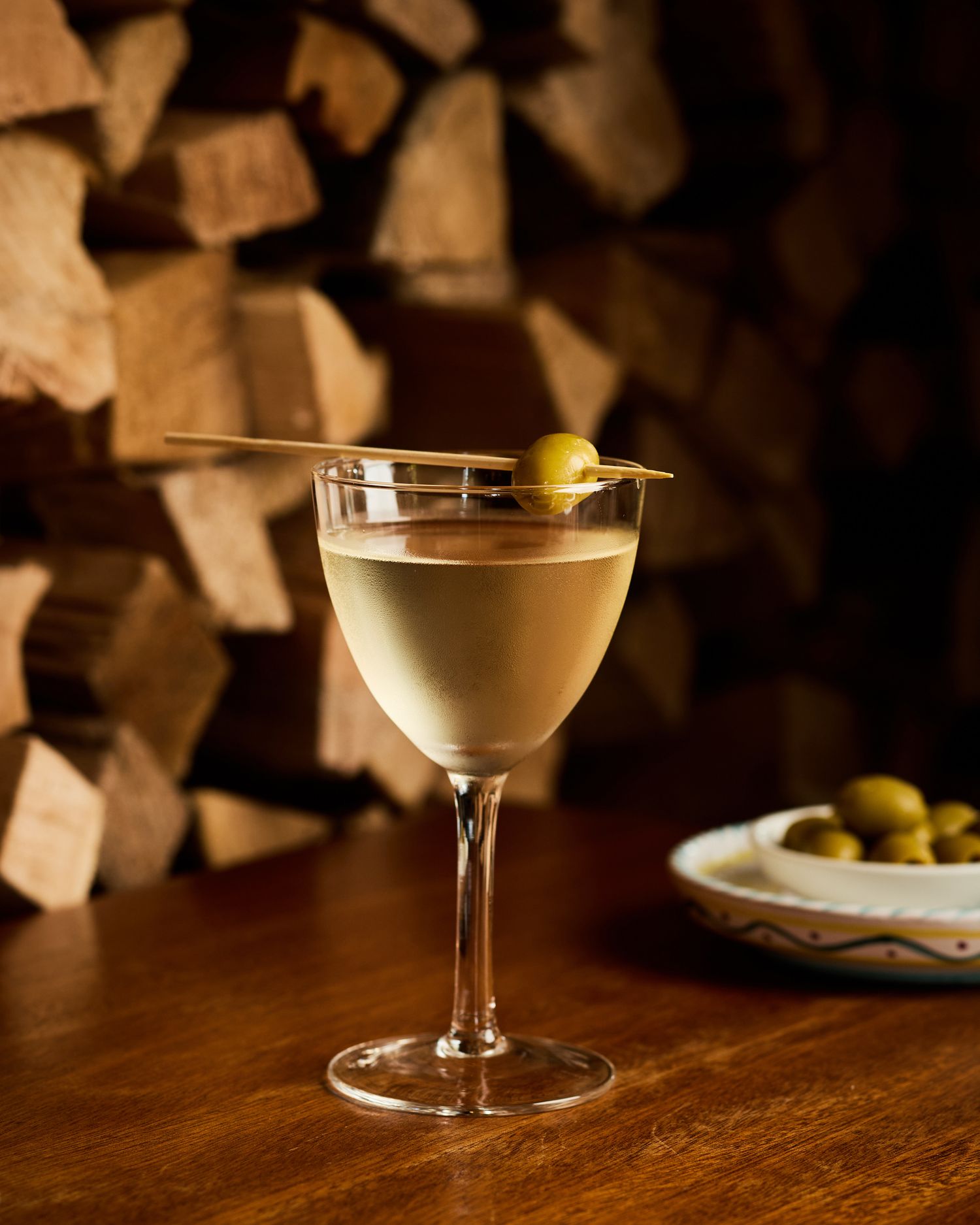 Classic martini cocktails served in coupe glasses on dark wooden bar.