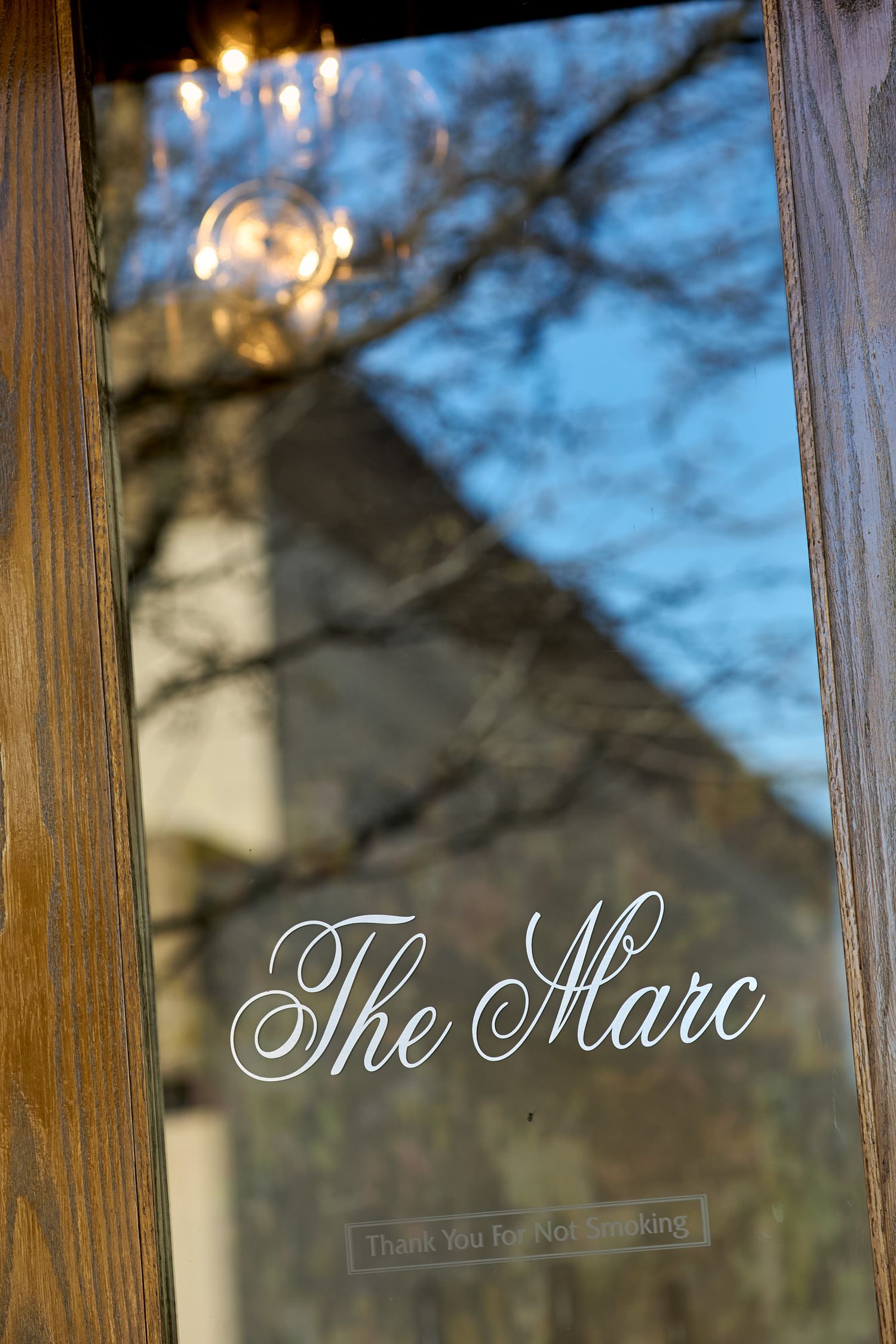 Frosted glass window with elegant script text reading 'The Shaw' in white lettering.