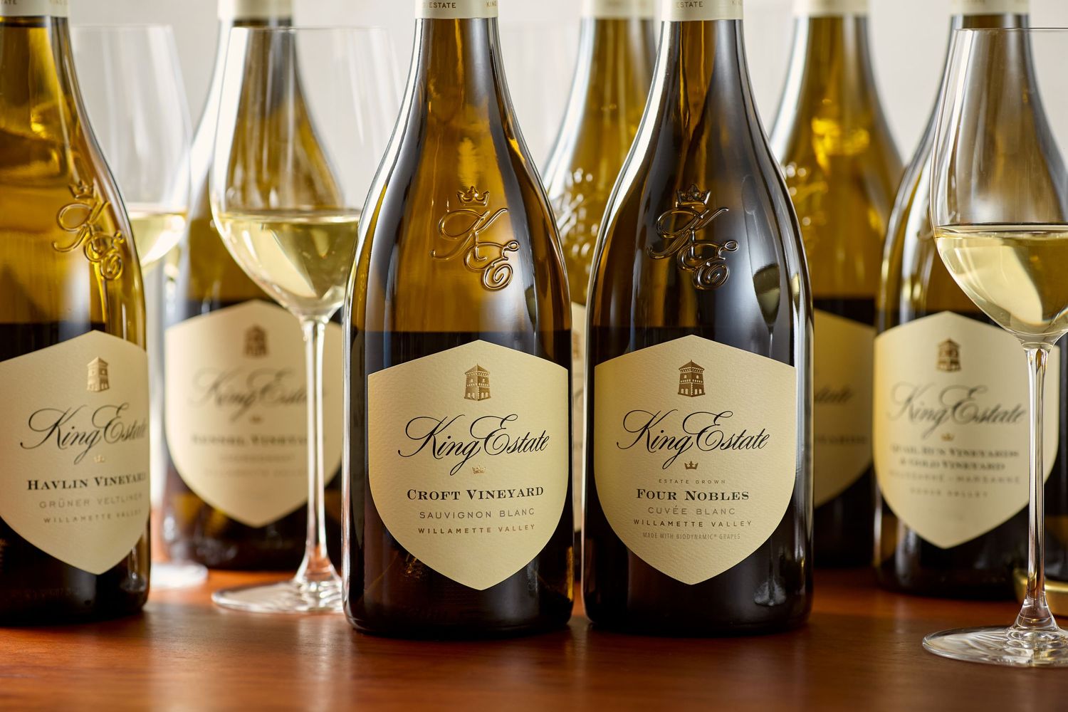 Collection of King Estate wine bottles lined up with wine glasses.