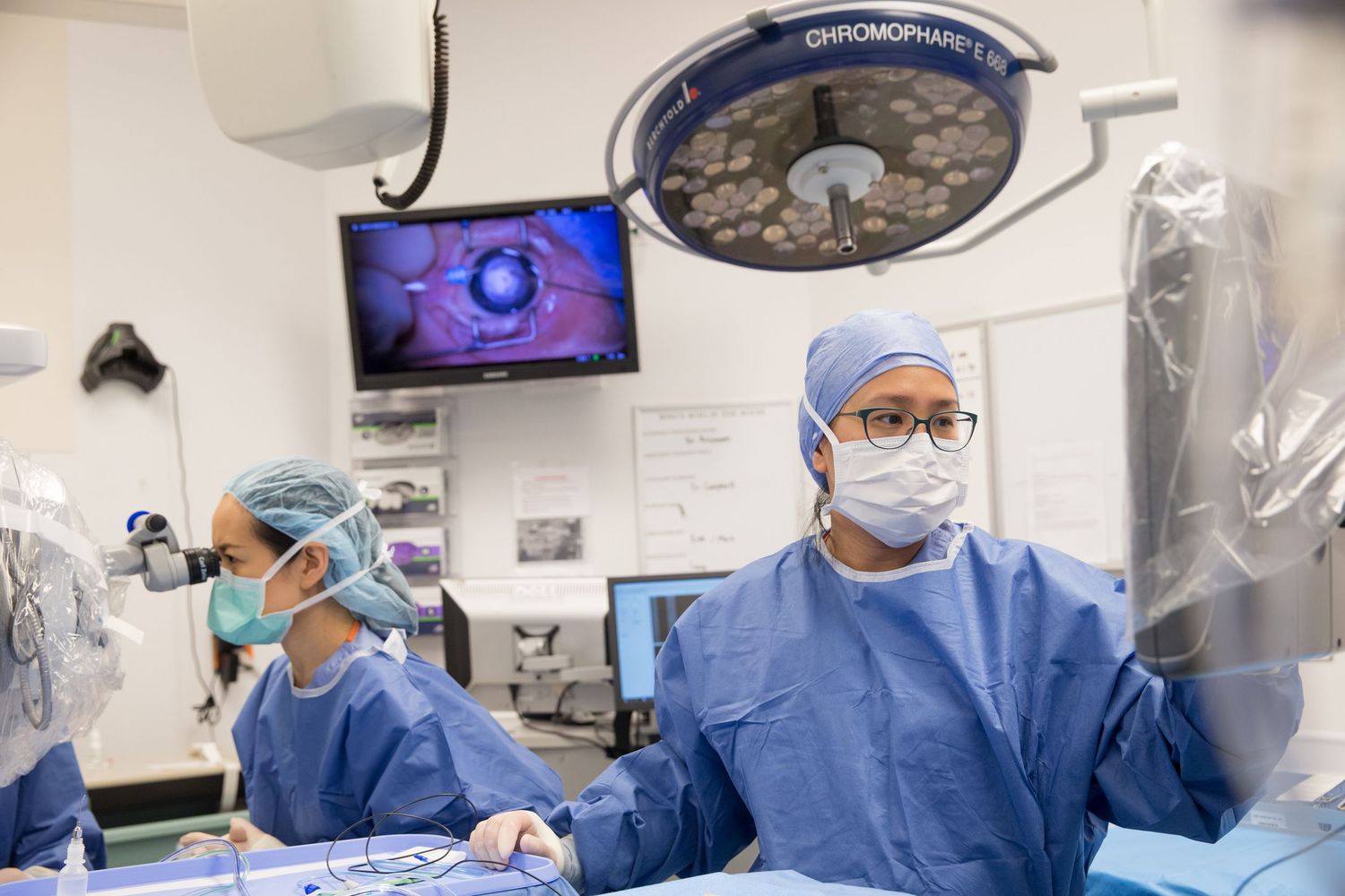 Surgical team performing operation in modern operating room with medical equipment.