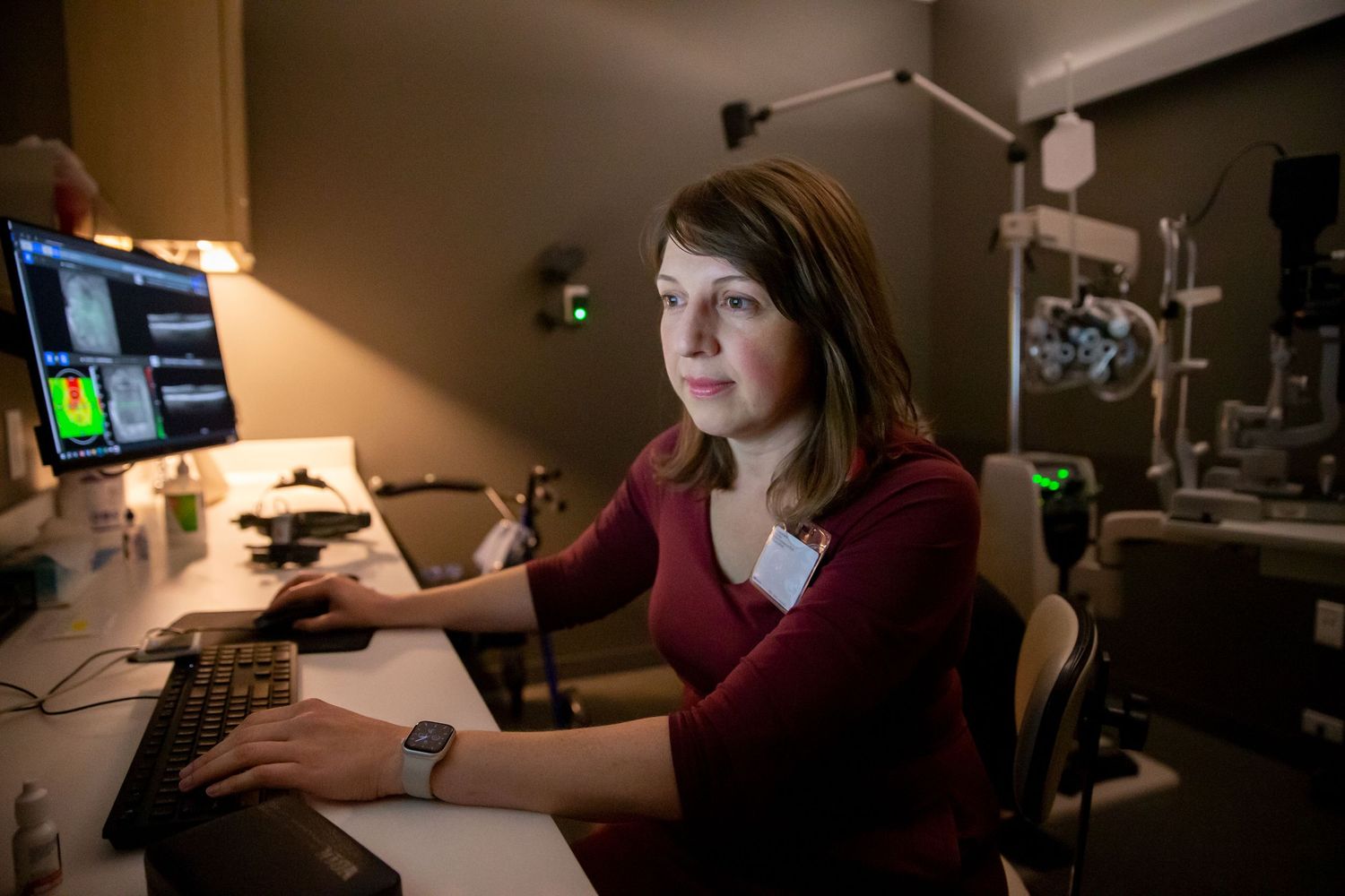Researchers working in darkened laboratory with specialized equipment.