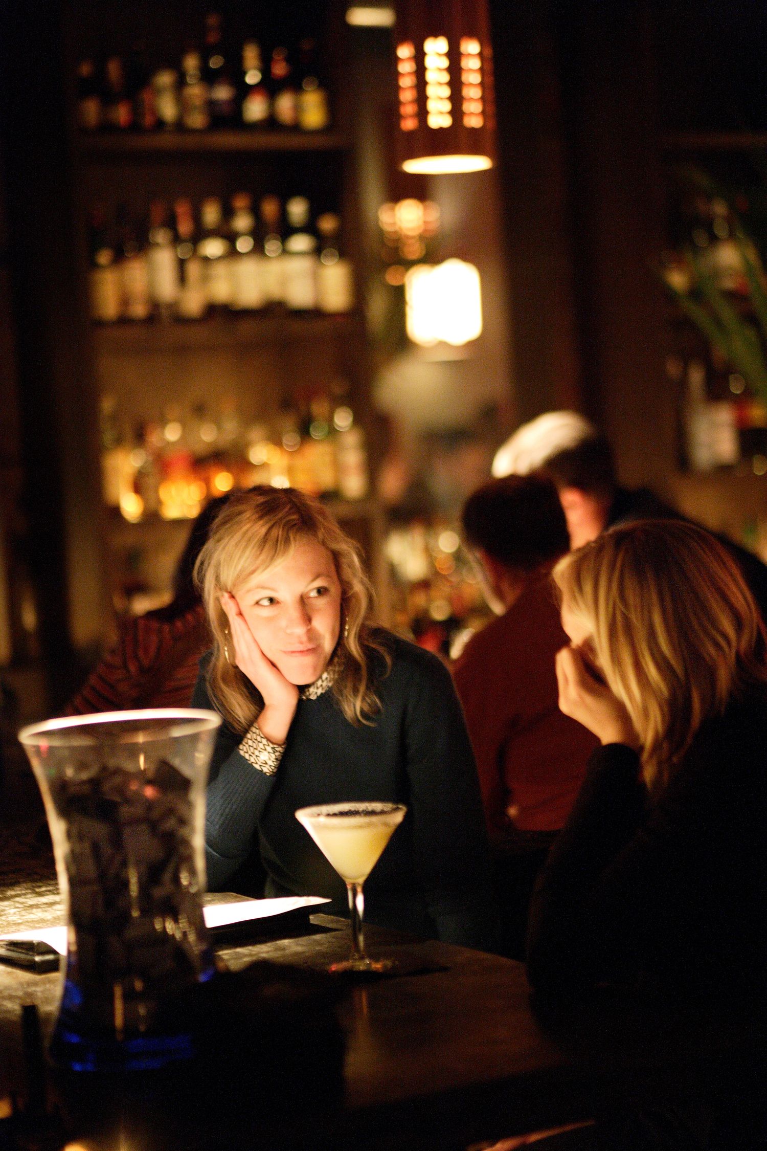 Dimly lit bar scene with cocktail glasses and ambient lighting creating intimate atmosphere.
