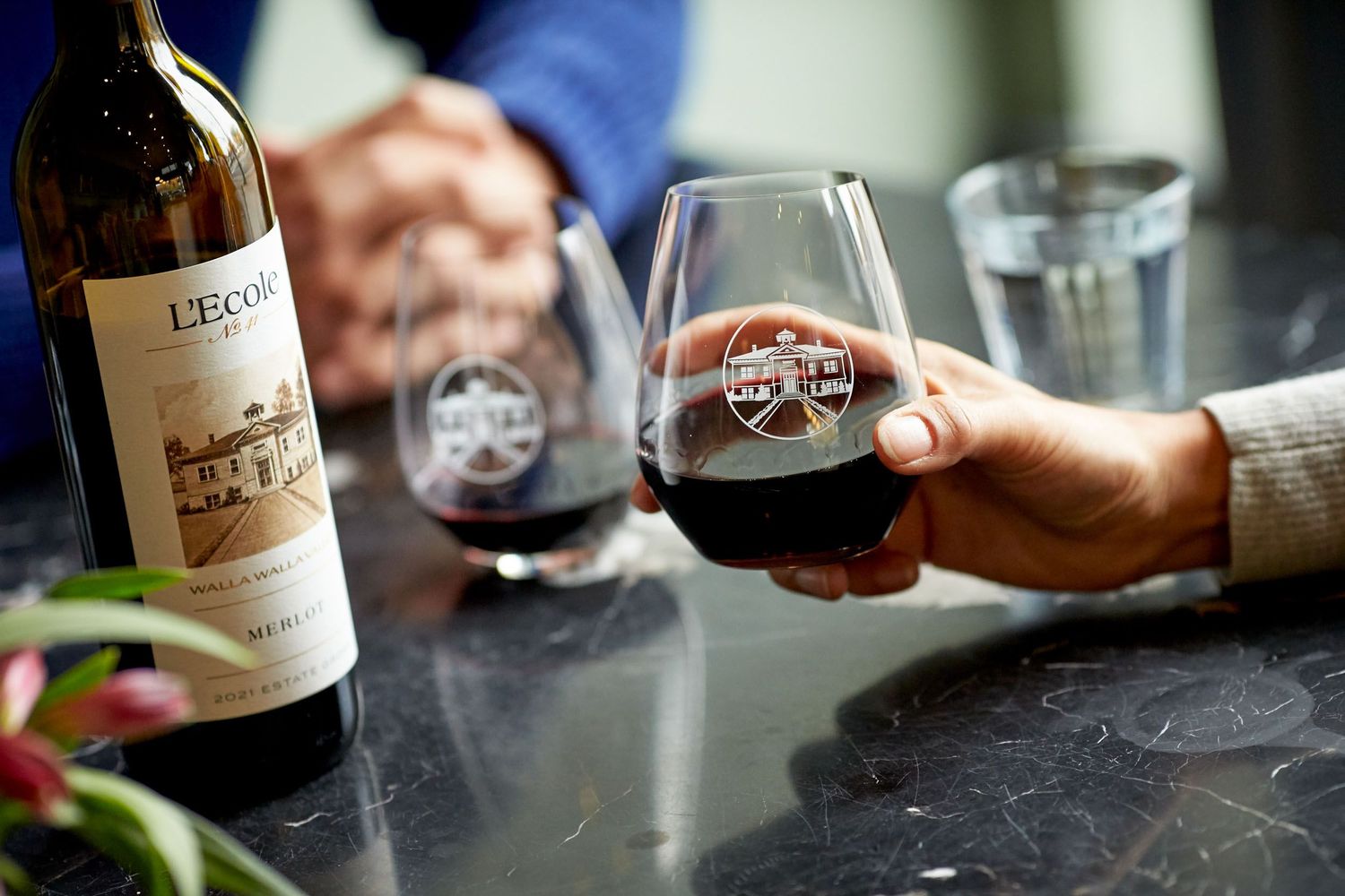 Close-up shots of wine glasses and bottles being served at an upscale restaurant.