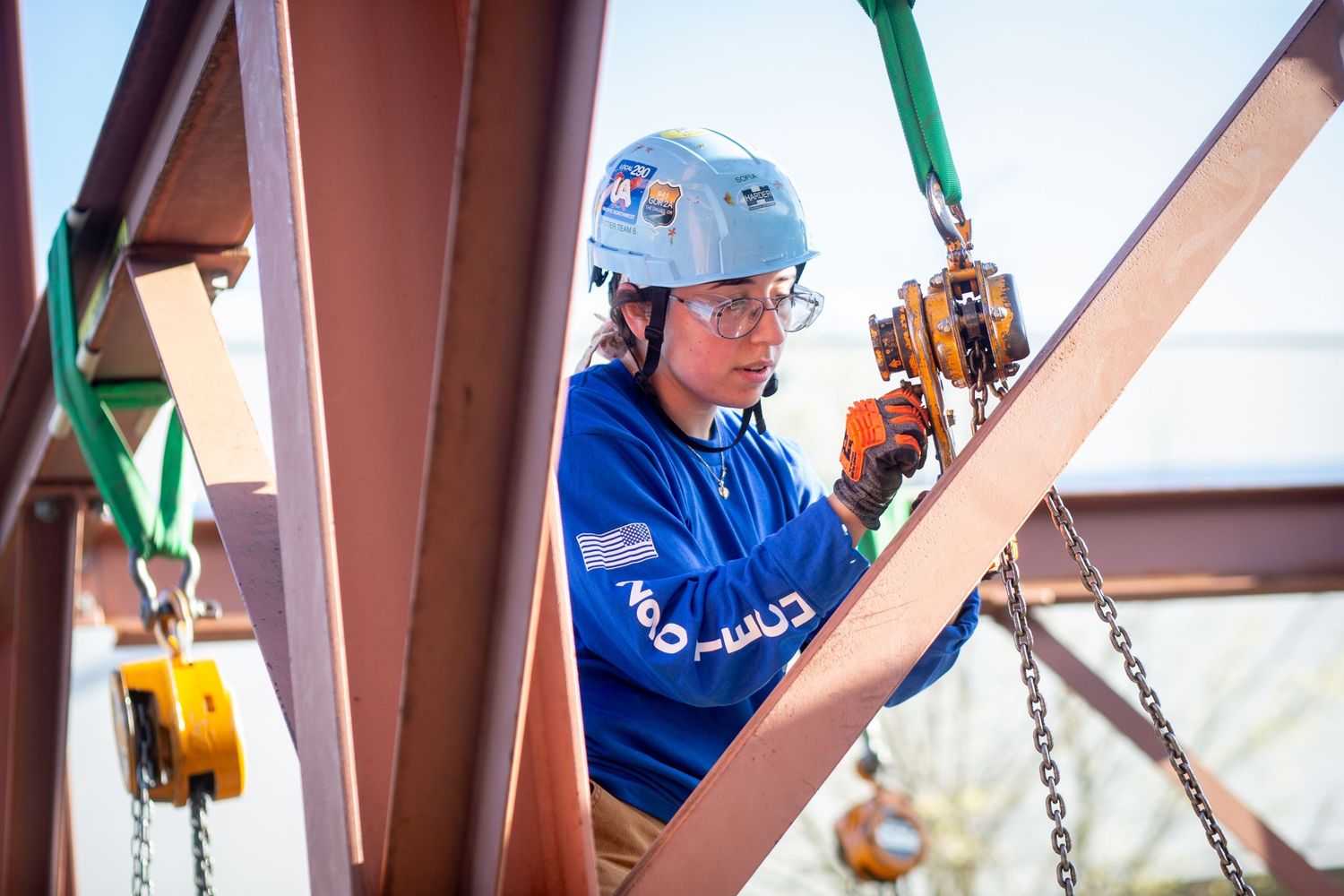 Industrial workers in blue safety gear operating equipment on construction site.