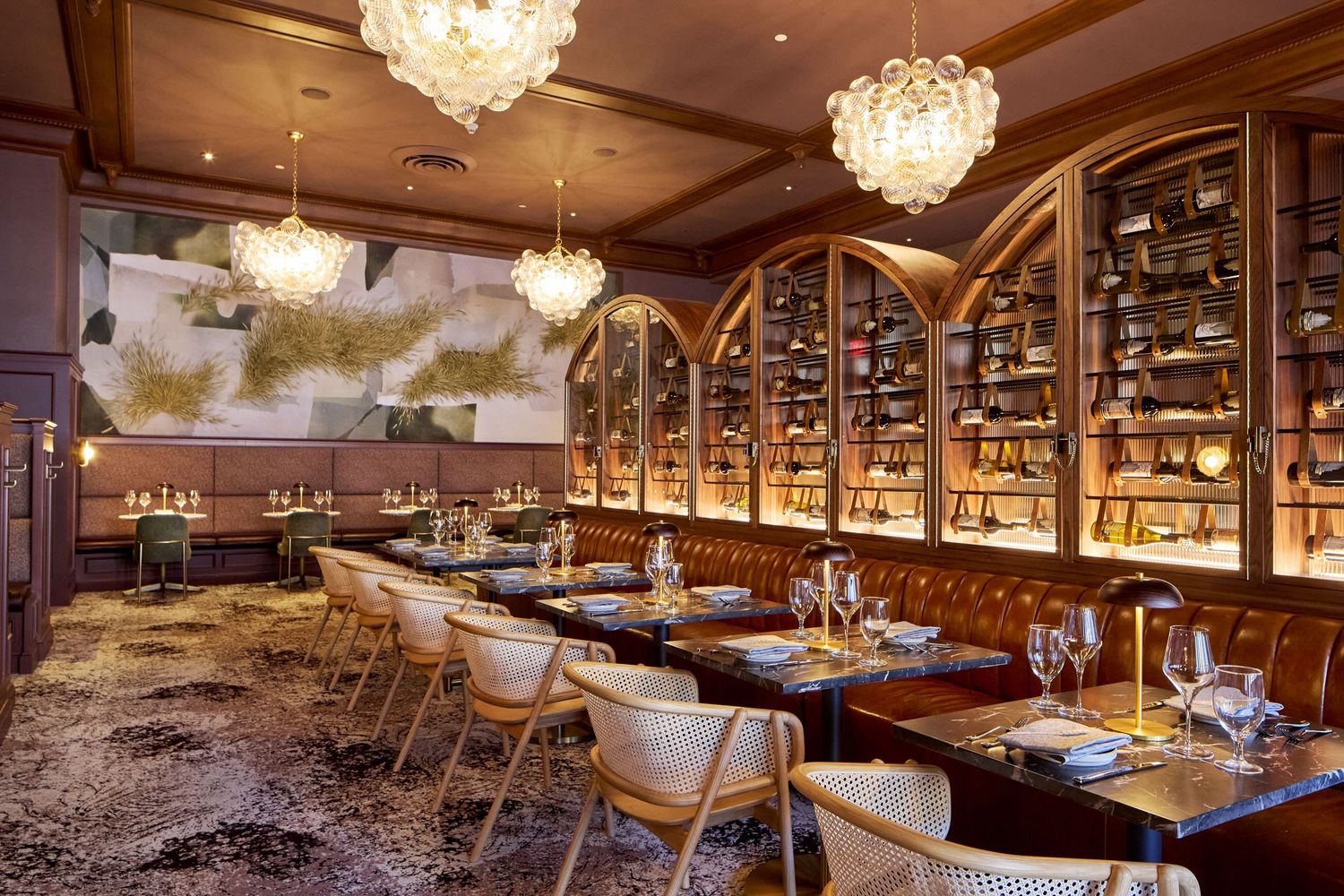 Luxurious restaurant interior with crystal chandeliers and warm wood finishes.