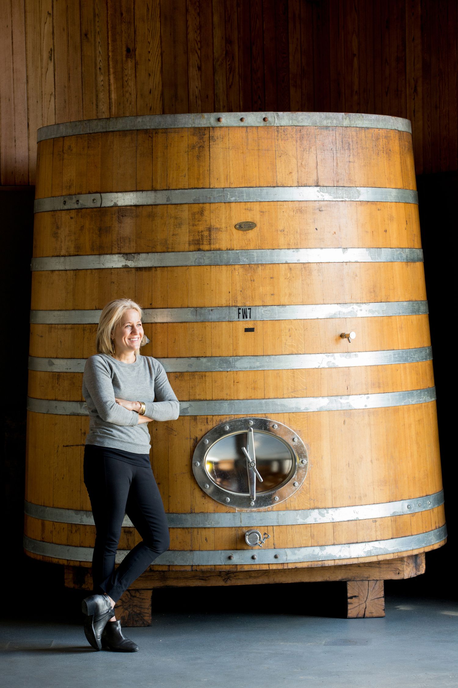 Large wooden wine fermentation barrels in traditional cellar storage room.