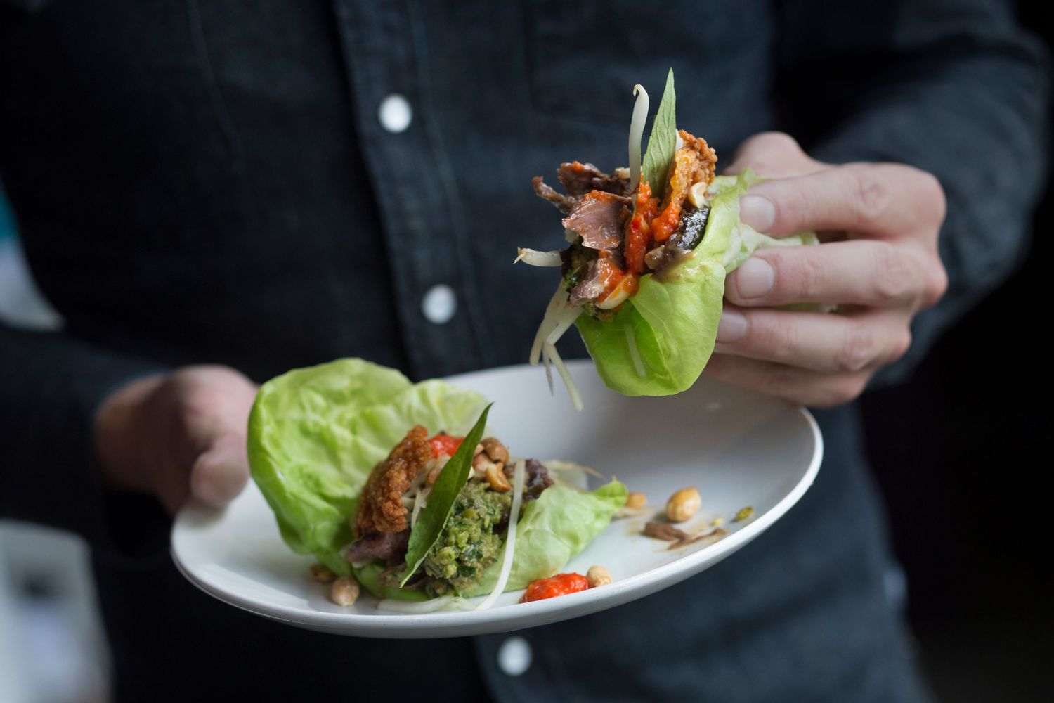 Chef plating elegant dishes with precision in professional kitchen.