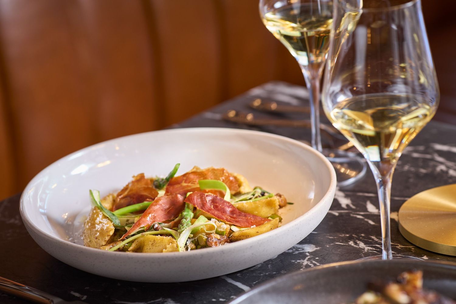 Elegant plated dishes with wine pairings in a fine dining setting.