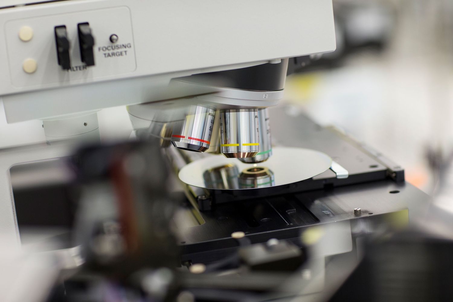Close-up of microscope lens examining sample in scientific laboratory.