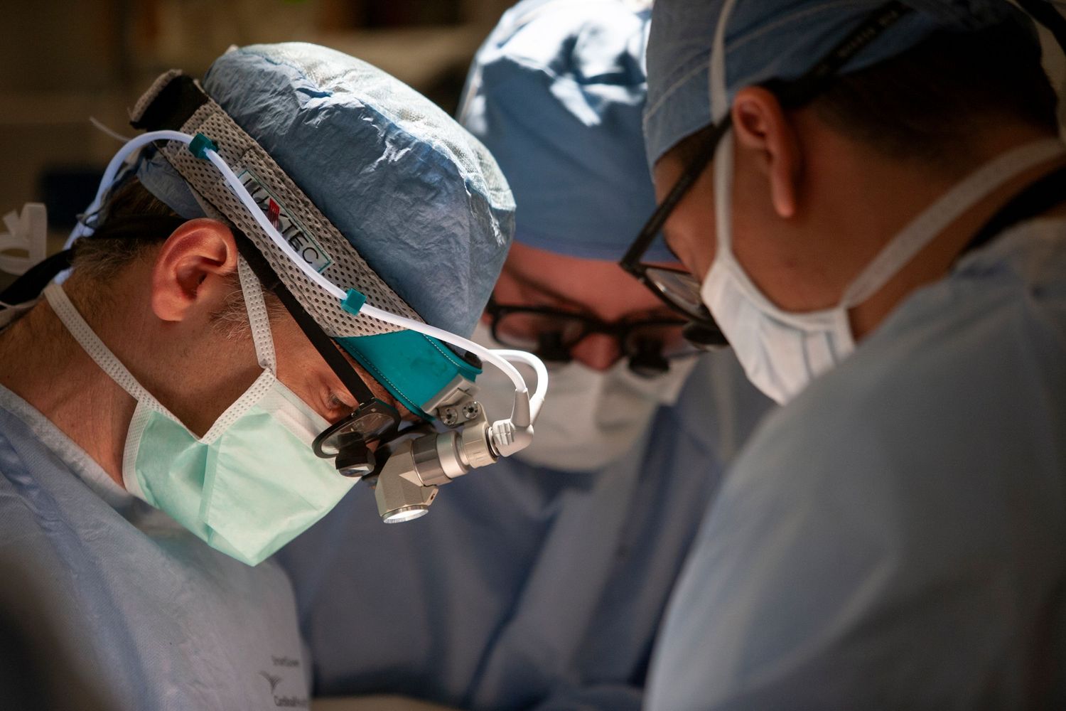 Surgeons performing operation in hospital operating room.