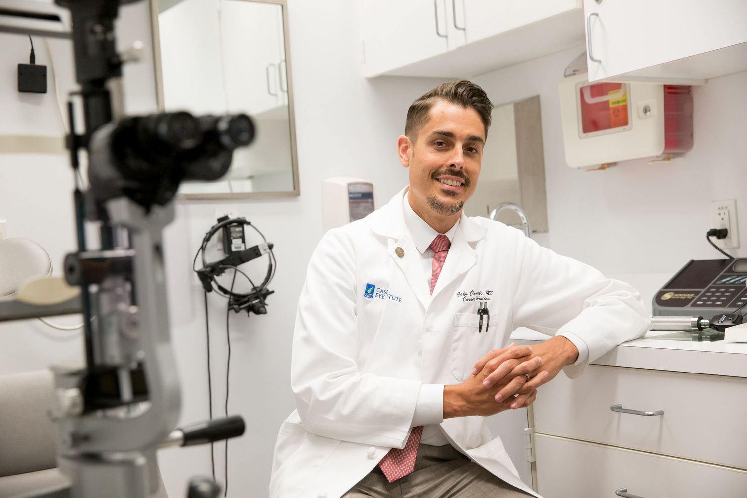 Doctor examining medical equipment in clinical laboratory setting.