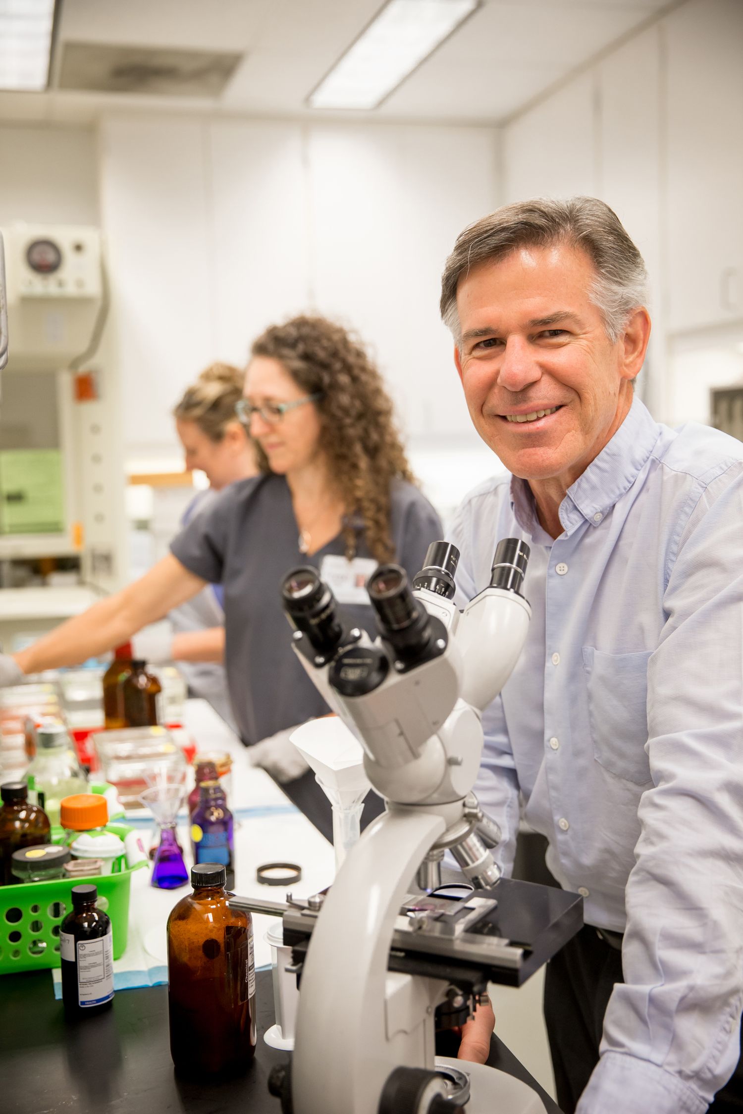 Researchers working with microscopes in a modern laboratory setting.