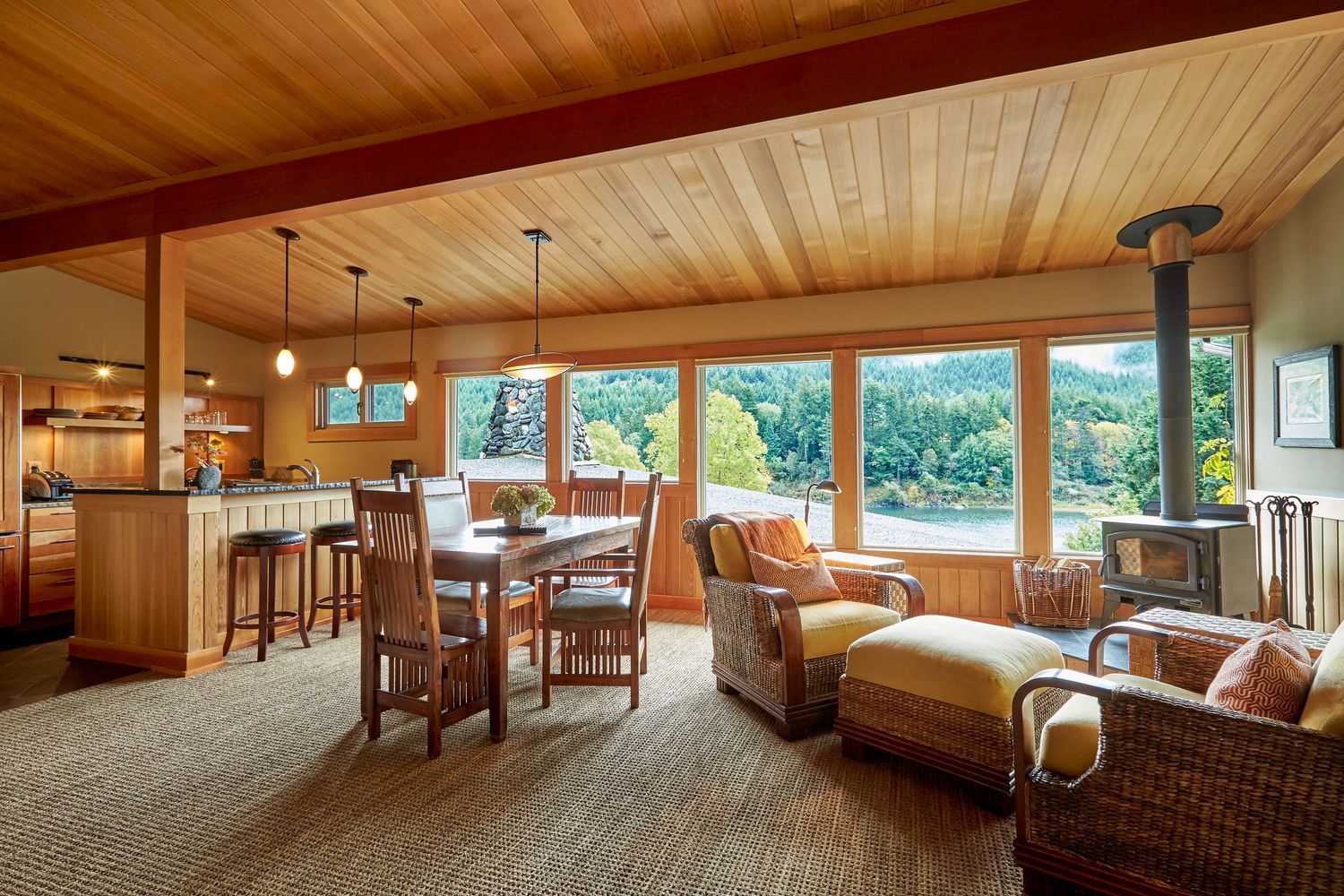 Open-concept living space with wood ceiling, panoramic windows, and comfortable seating area.