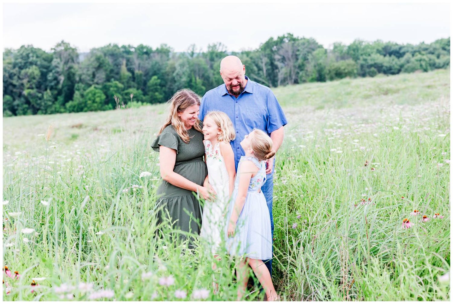 A group shares a candid moment together in a sunlit wildflower meadow.