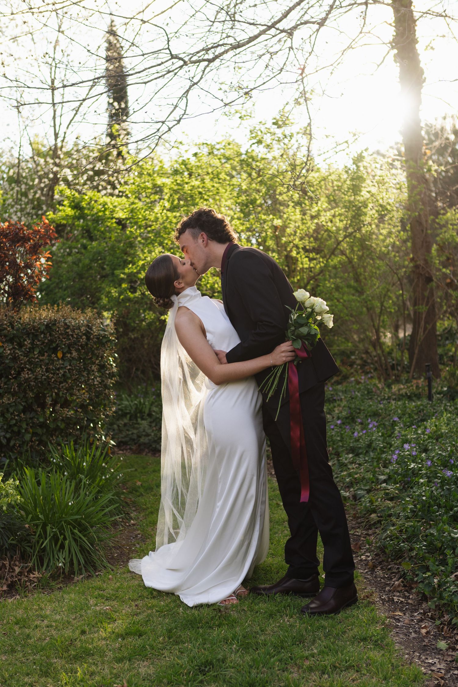 bride and groom kissing in garden