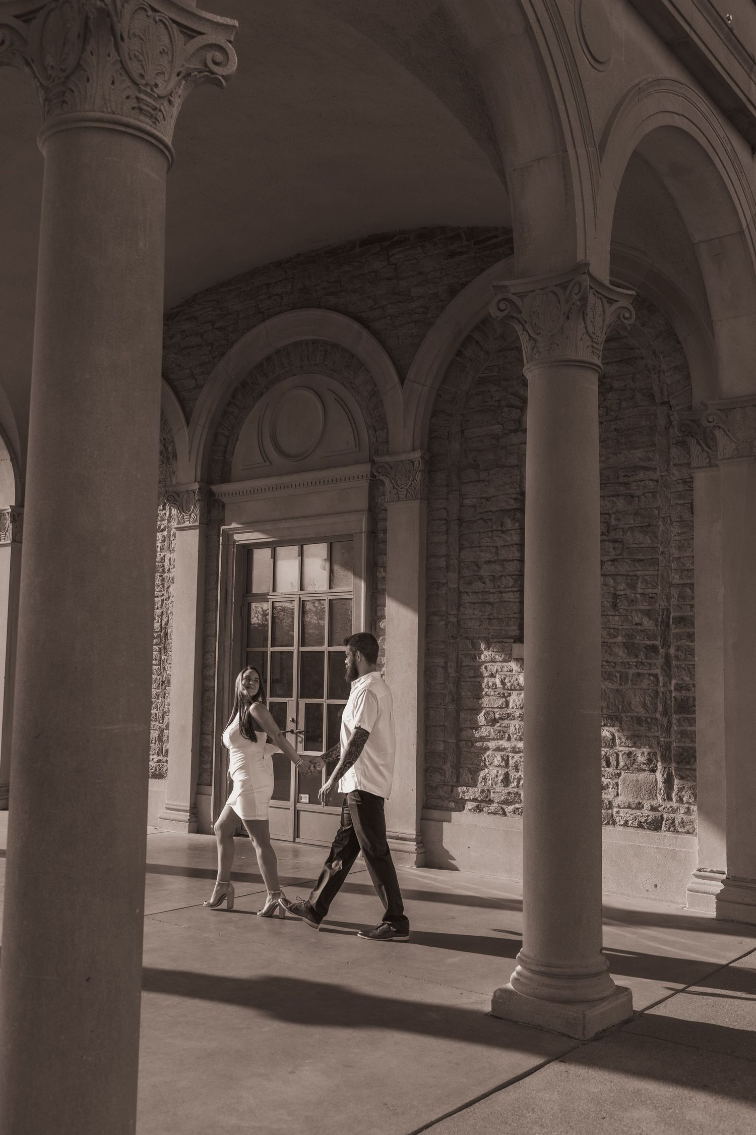 Couple walk through the arches of Ault Park in Cincinnati, OH. Photographed by Vicci Photo of Dayton, OH.