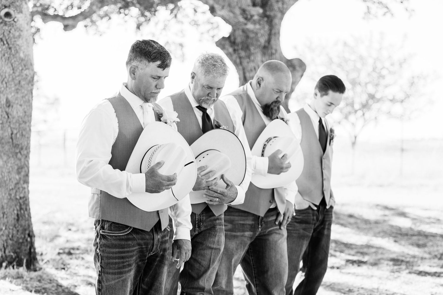 A group of smiling young men in casual attire walk together in a park-like setting in this vintage black and white photograph.