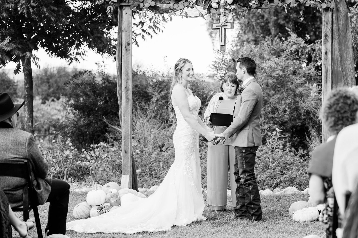 Black and white montage image of small wedding ceremony taking place outdoors under trees in a garden setting.