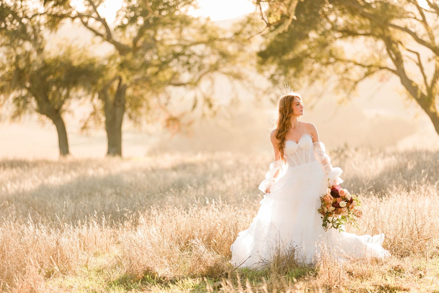 Wedding couple embraces in a sun-drenched golden field at sunset with dreamy bokeh lighting.