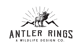 Monochromatic wildlife company logo with elk silhouette and sunburst pattern.