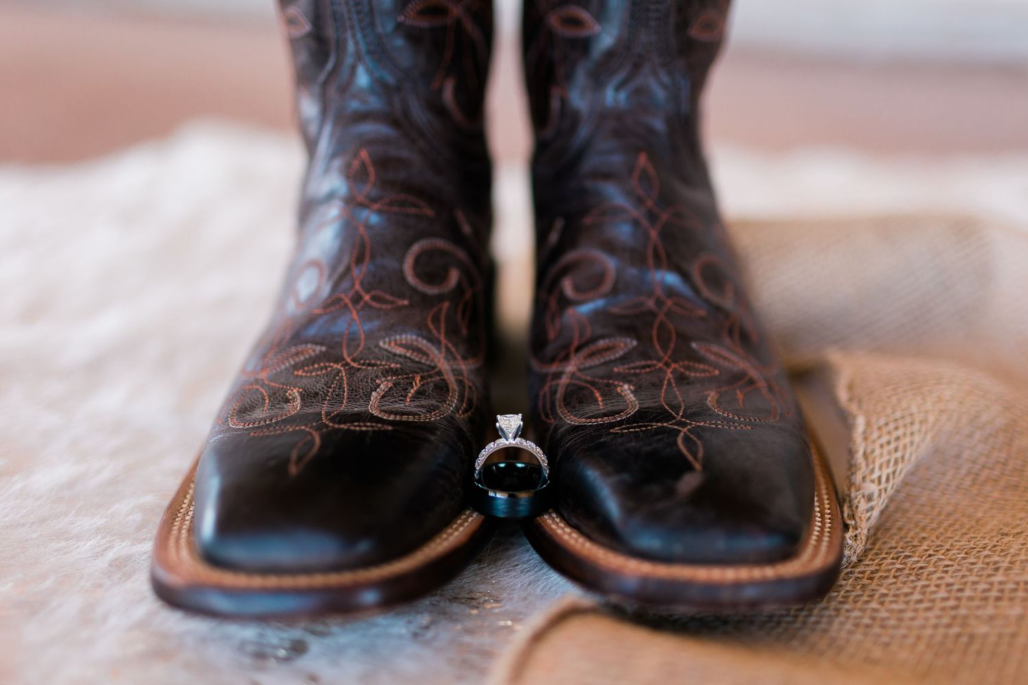 Close-up details of ornate brown leather cowboy boots with intricate stitching patterns.