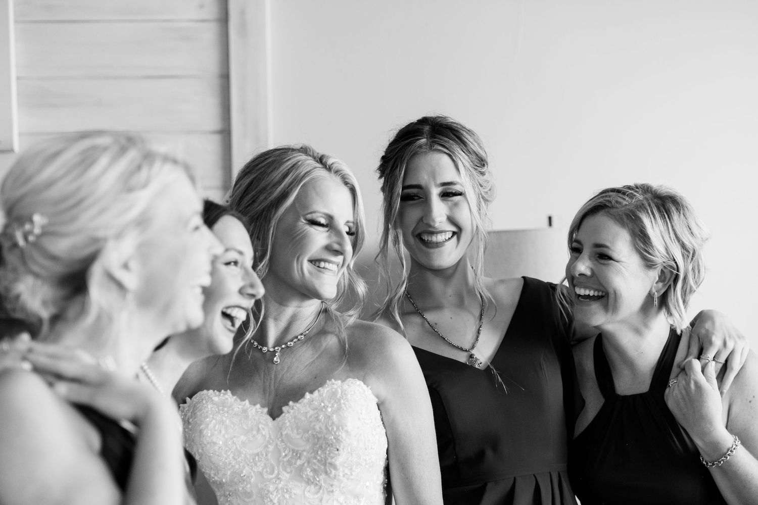Black and white photo series capturing candid laughter and joyful emotional moments between people at an event.