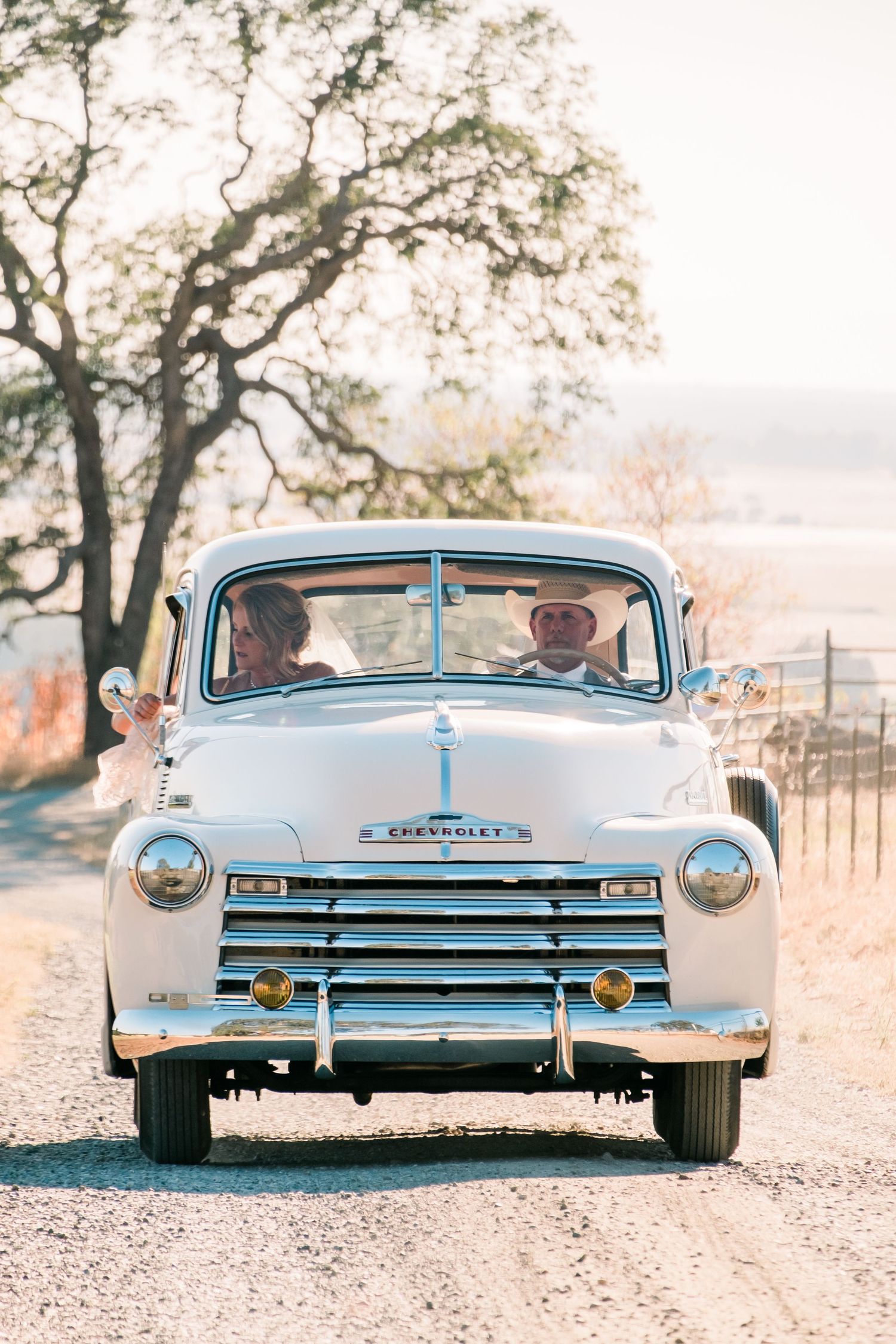 Vintage light blue classic car shown from three different rear angles against a soft sunset background.