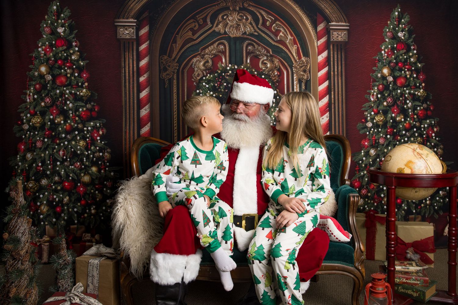A family wearing matching Christmas pajamas poses in front of a decorated tree in a festive holiday setting.