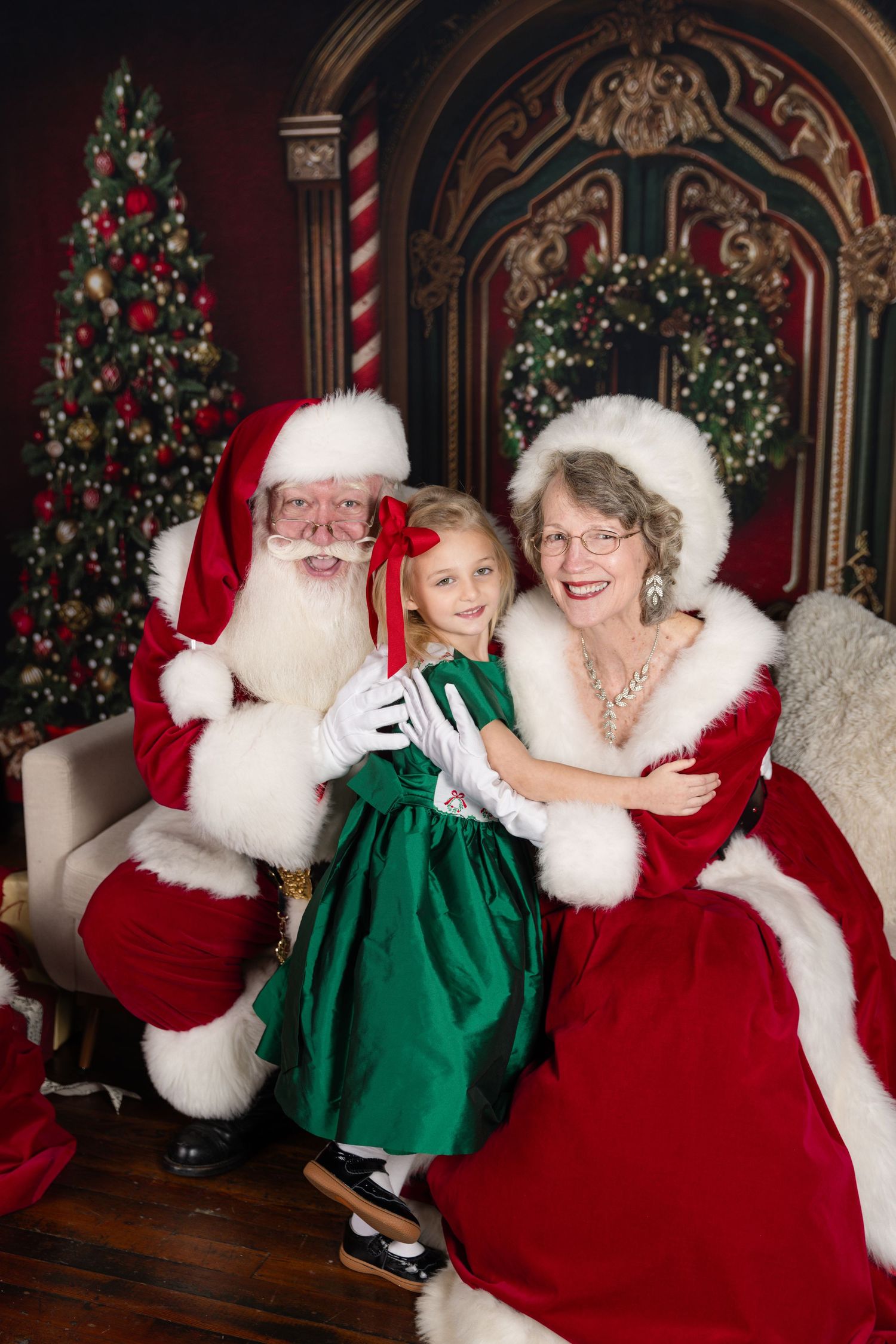 A festive holiday scene shows Christmas trees and decorative arches with traditional red and green colors in a studio setting.