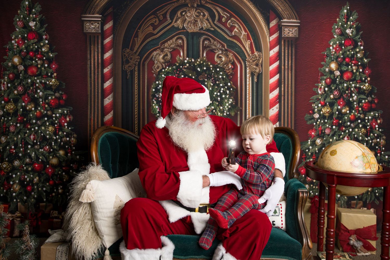 Festive holiday photo set with Christmas trees, red velvet thrones, striped candy cane pillars, and traditional decor.