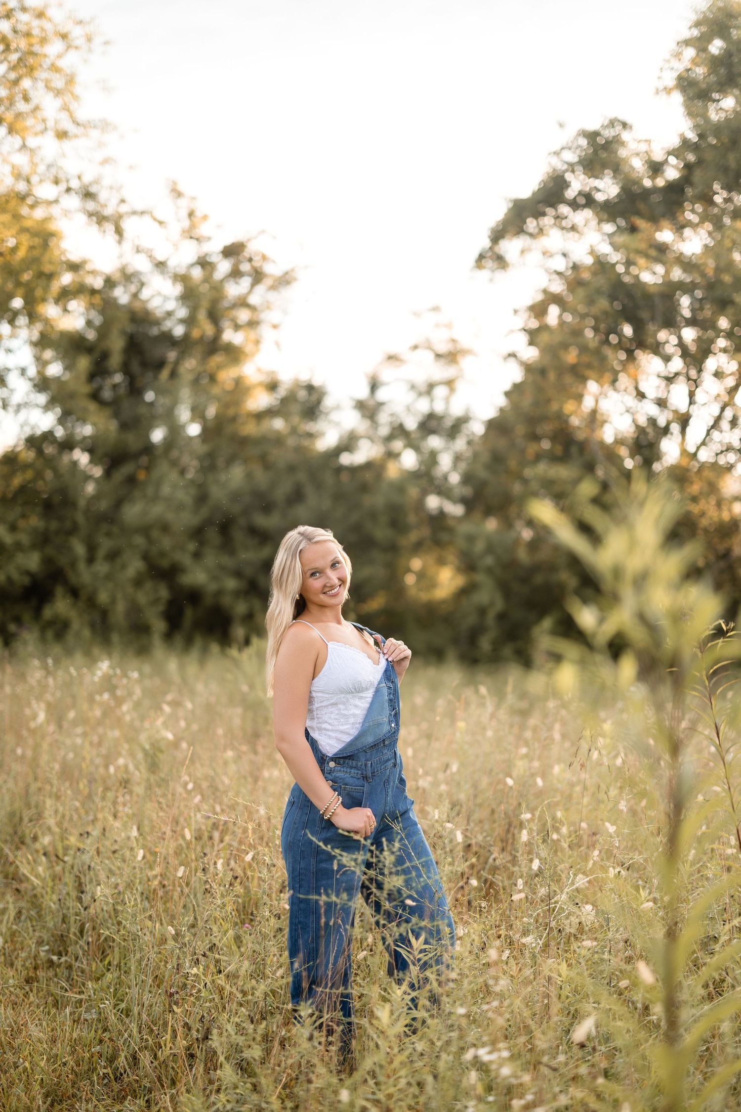 A couple embraces in a sun-drenched meadow filled with wildflowers during golden hour.