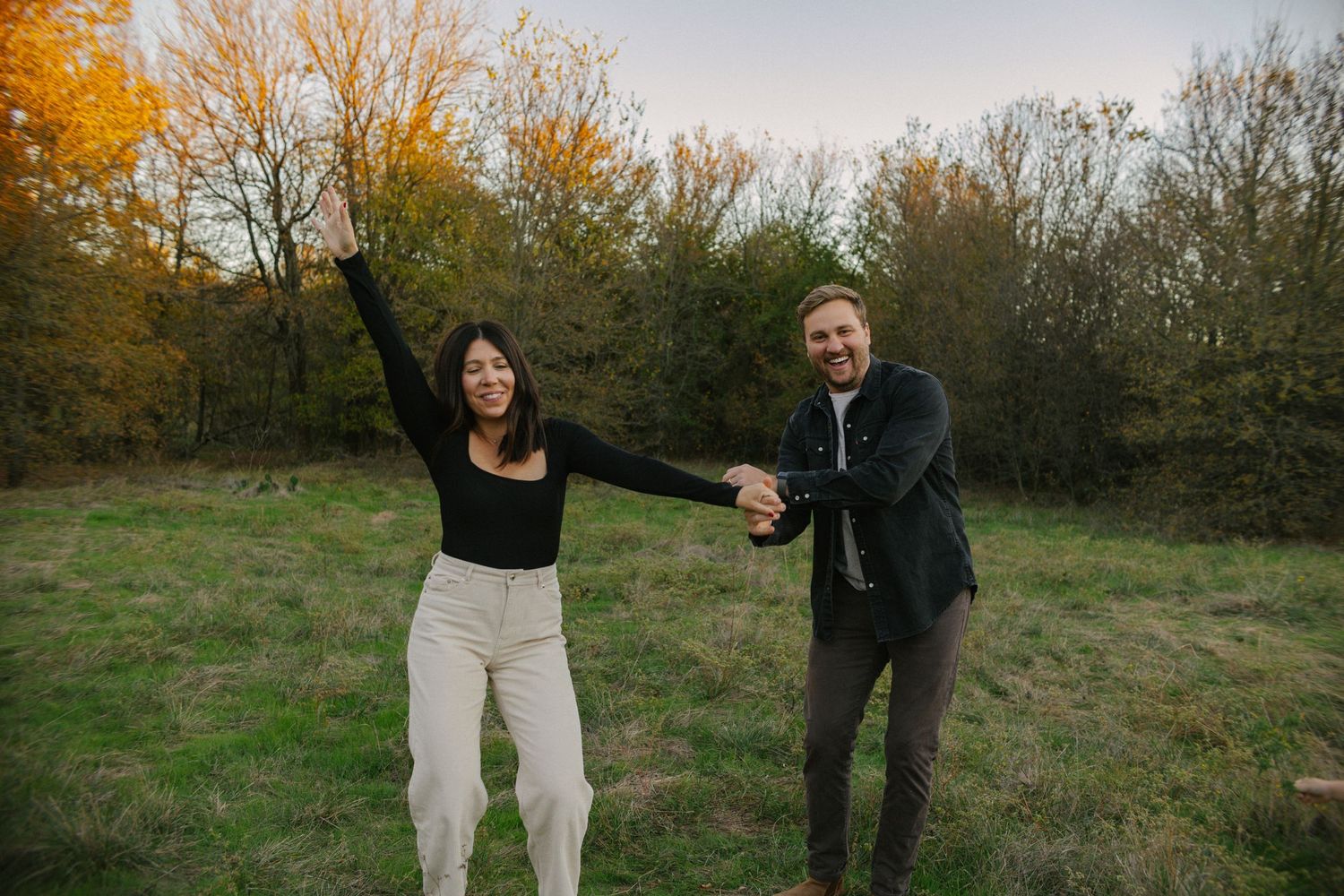 husband and wife dancing in a field