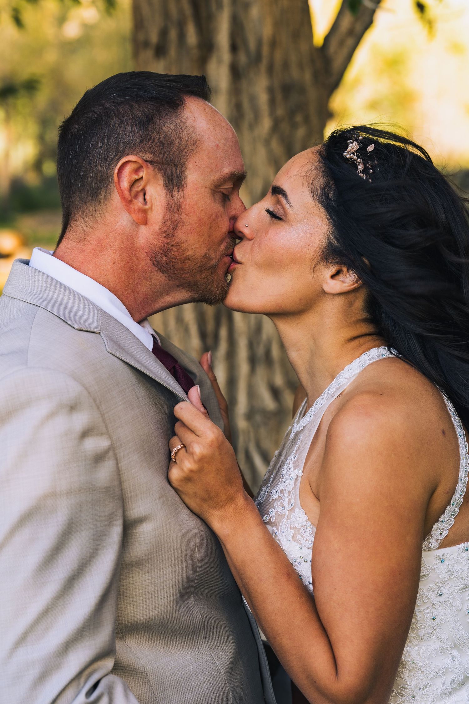 A couple in wedding attire share a tender kiss outdoors in a series of romantic photos.