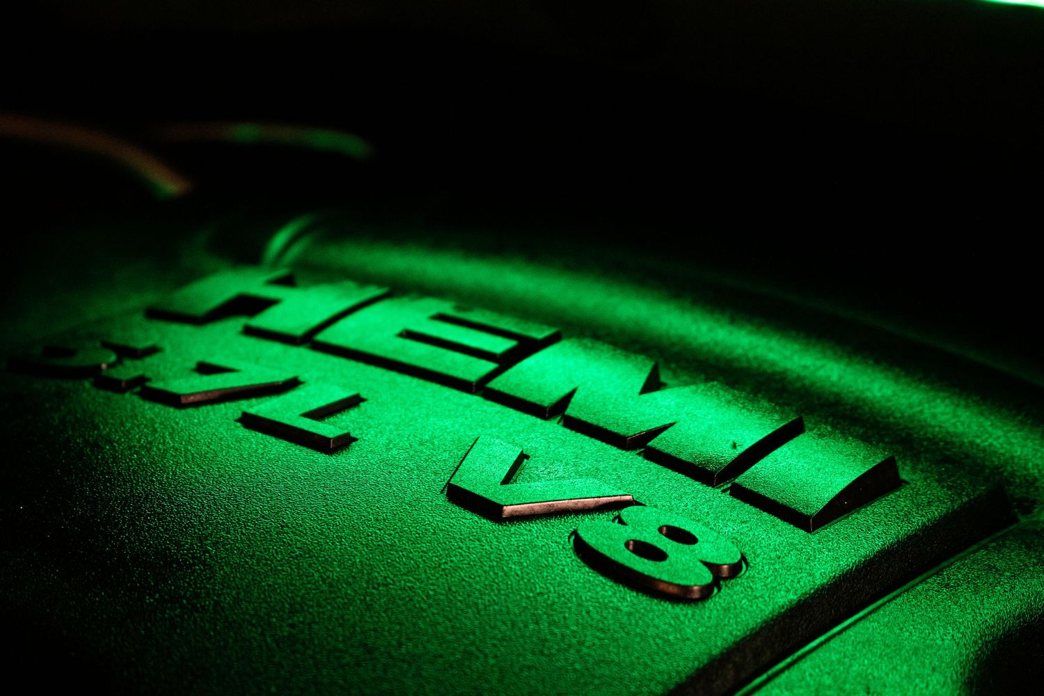 Keyboard keys illuminated in green neon lighting creating a dramatic tech aesthetic effect.