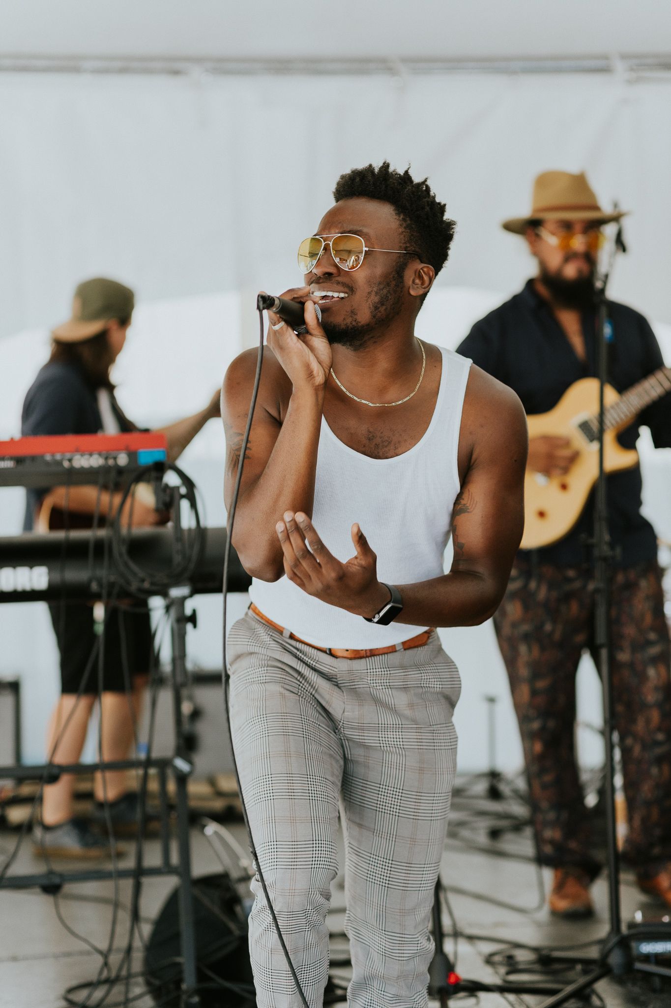 Energetic live music performance with singer and band members on outdoor stage.