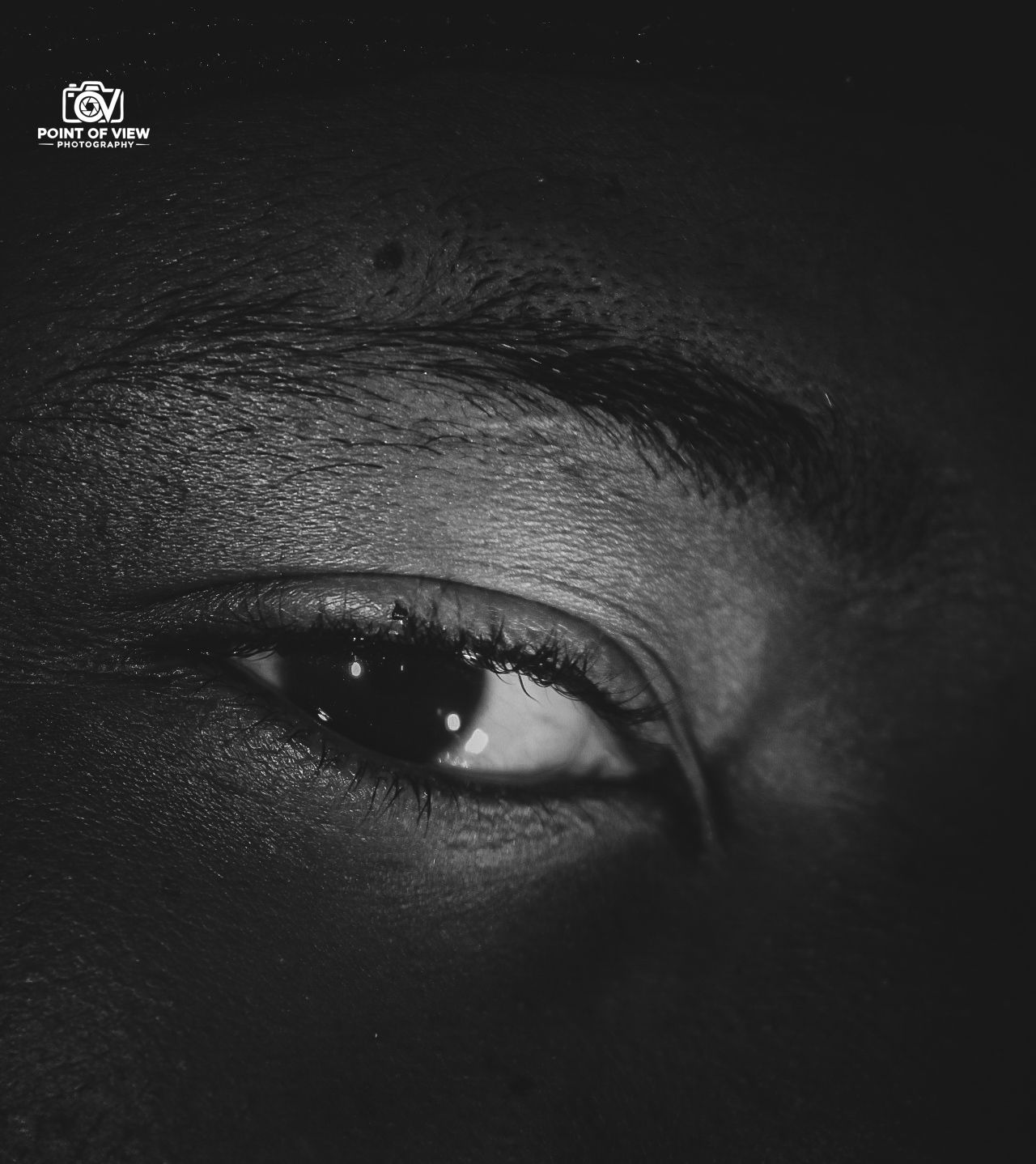 Dramatic black and white extreme close-up of a human eye with eyeliner.
