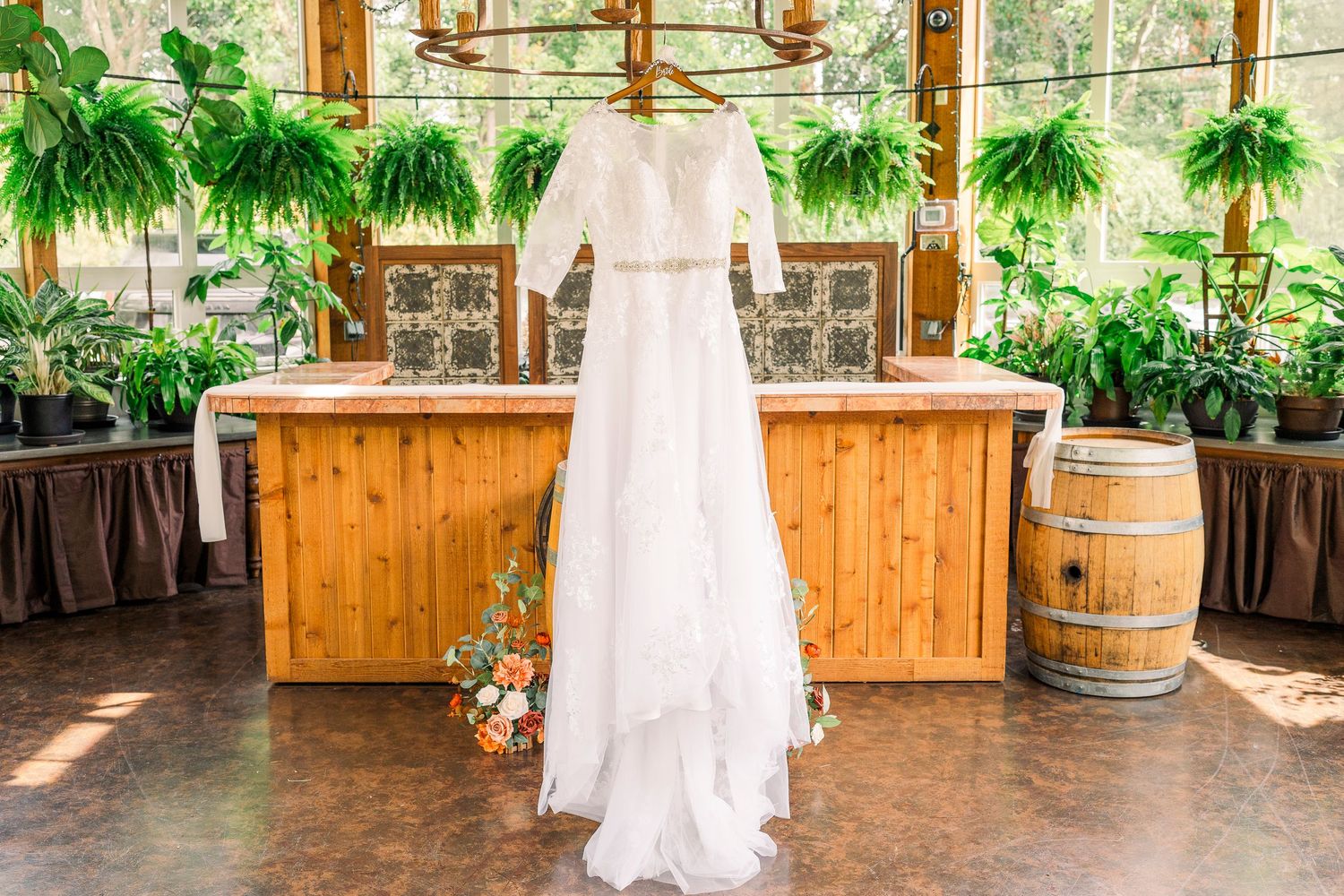White lace bridal gown displayed in the conservatory at Gervasi Vineyard wedding venue.