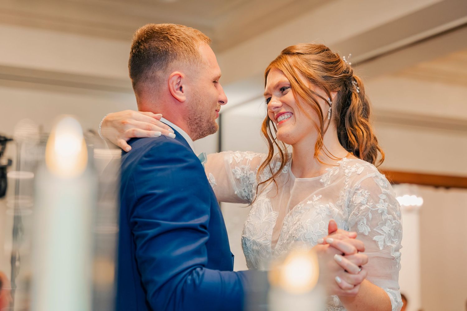 Bride and groom sharing their first dance, gazing lovingly at each other.
