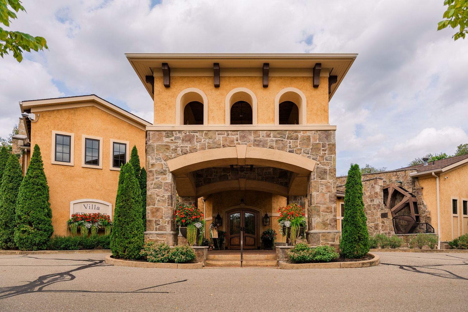 Elegant Italian-style Gervasi Vineyard entrance with stone archway and manicured landscaping.